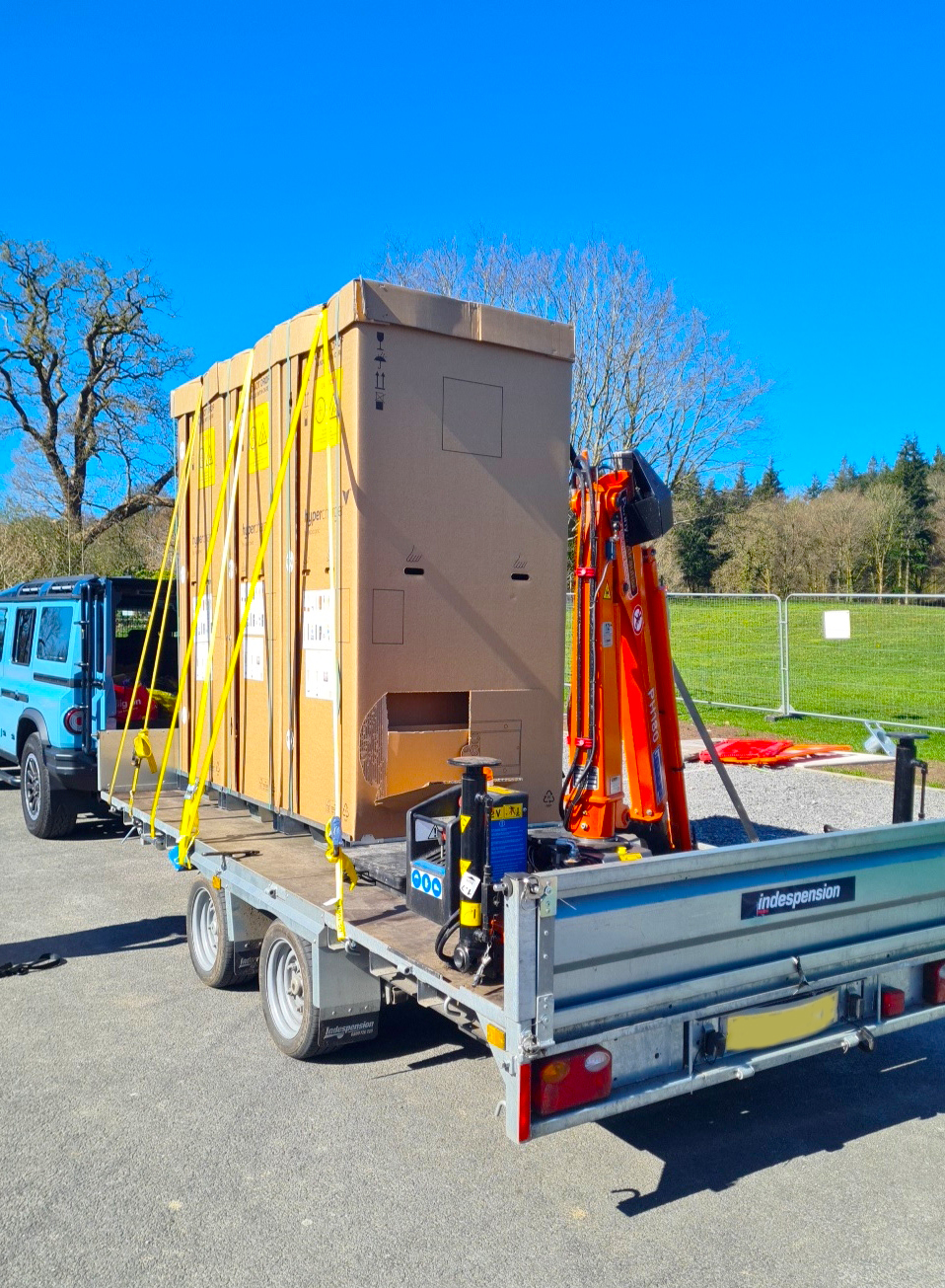 HIAB-equipped trailer loaded with a large crated unit secured with ratchet straps