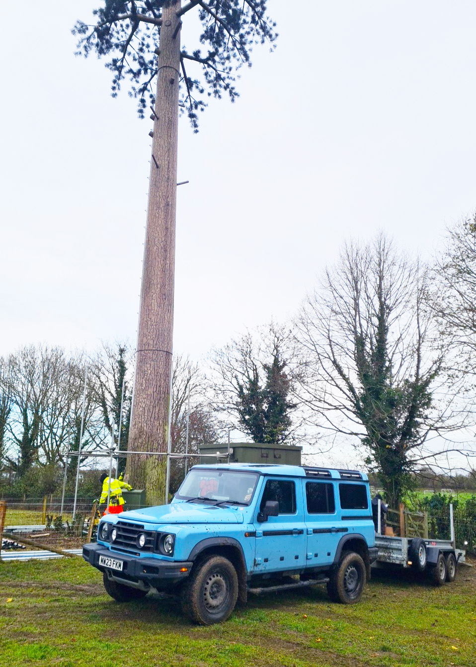 AGL 4x4 and plant trailer parked beneath a tree-disguised telecoms mast