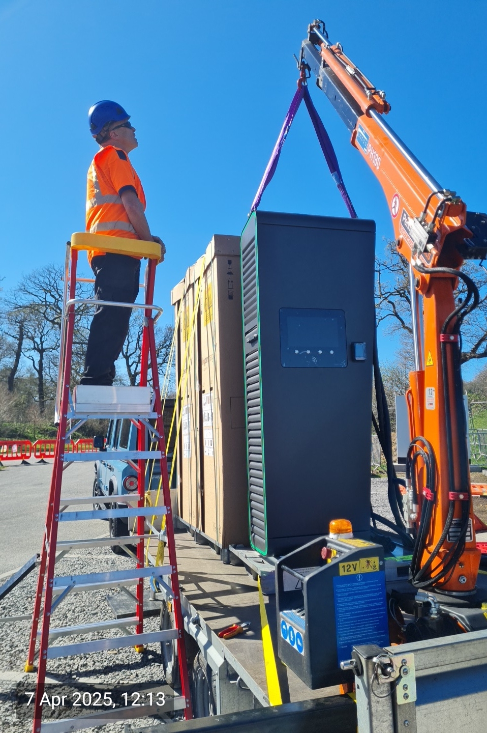 HIAB lifting an EV rapid charger clear of the trailer bed