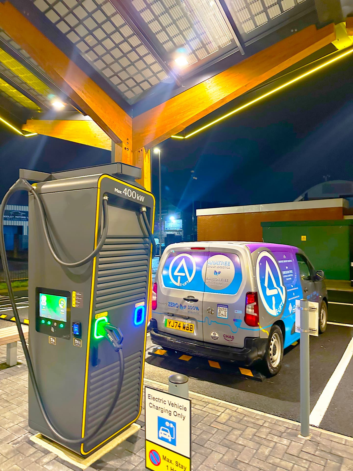 AGL E-LIFT electric van charging at a rapid charging canopy at night