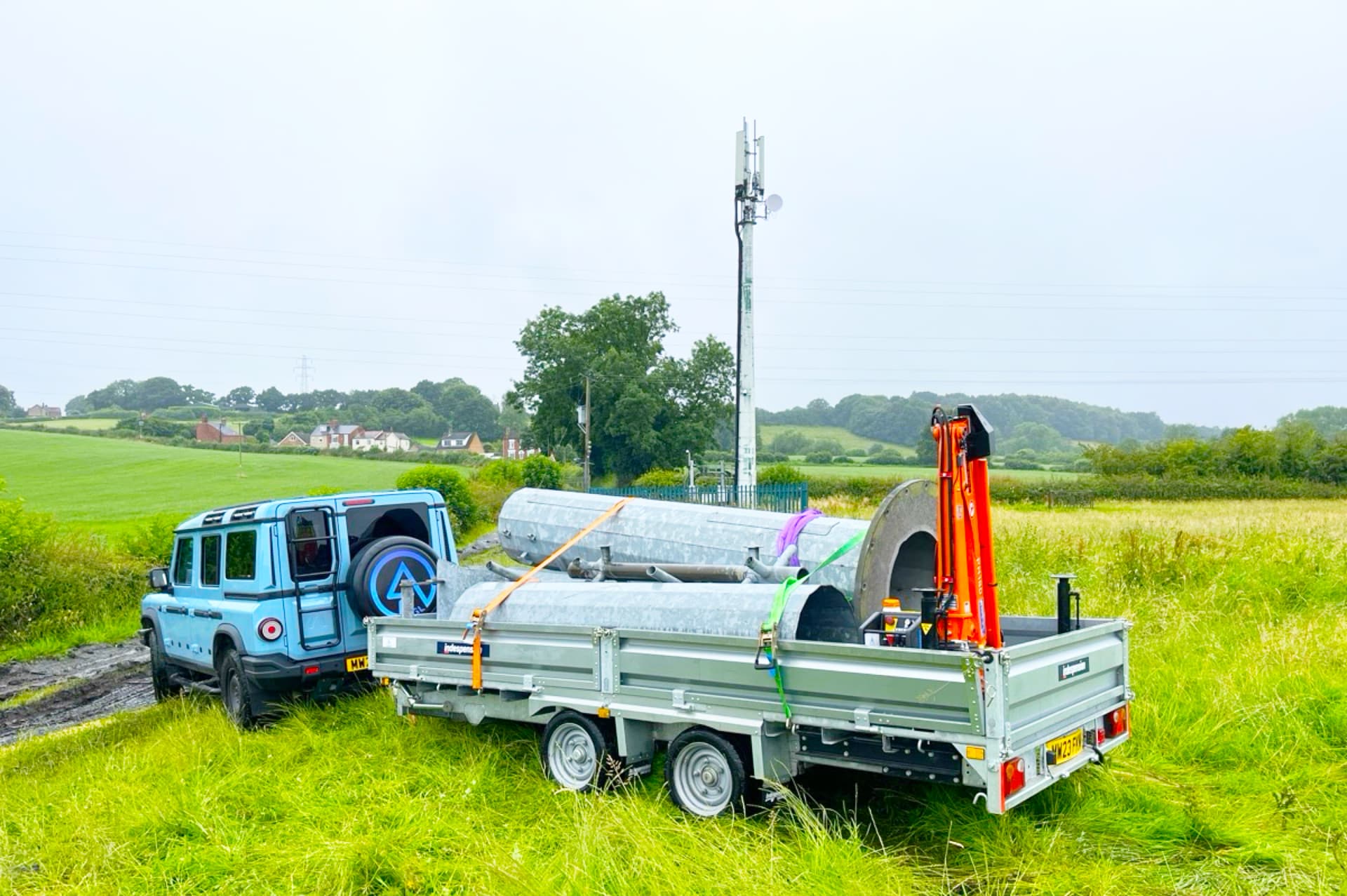 AGL 4x4 and HIAB trailer carrying galvanised sections across a rural field