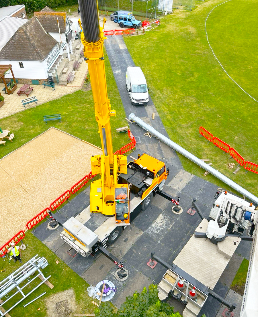 Aerial view of a mobile crane fully outriggered on ground protection matting